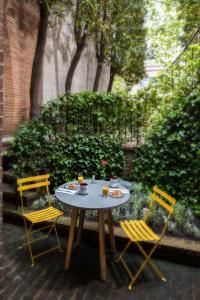 The Poppy Georgetown Guesthouse and Gardens في واشنطن: طاولة عليها كرسيين وطاولة عليها طعام
