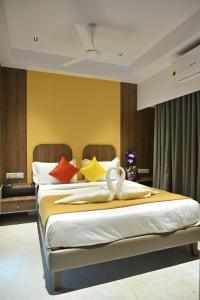 1 dormitorio con 2 camas y almohadas coloridas en Hotel The Faam, en Rajkot