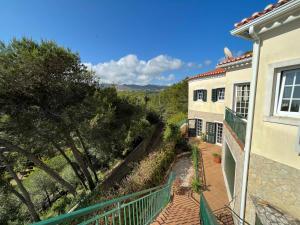 een balkon met uitzicht op een huis bij Amazigh Guincho Hostel & Suites in Cascais