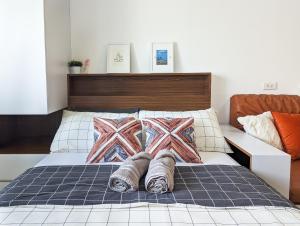 a bed with two blankets and pillows on it at Studio Condo Manila by the Bay Roxas Blvd near US Embassy in Manila
