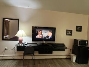 a living room with a flat screen tv on a wall at Central Motel in Fort Morgan +3 photos