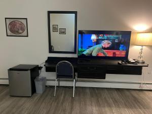 una sala de estar con TV de pantalla plana en una cómoda en Central Motel, en Fort Morgan