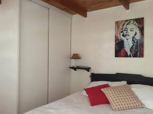 a bedroom with a bed and a painting on the wall at Linda y cómoda casa interior entera/independiente in San Pedro de la Paz
