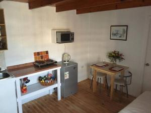 a small kitchen with a table and a microwave at Linda y cómoda casa interior entera/independiente in San Pedro de la Paz