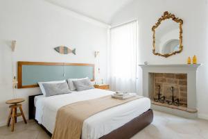 Dormitorio blanco con cama y chimenea en La Casa sulle Mura, en Montecchio Emilia