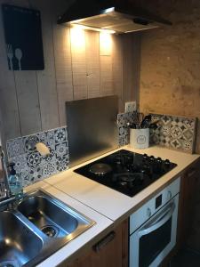 a kitchen with a sink and a stove at « Le Vieux Hangar » gîte à la ferme in Truffe