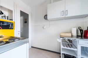 uma cozinha com armários brancos e um forno com placa de fogão em Cooldis 5 !Gratis Parken, Free Parking! em Kreuzlingen