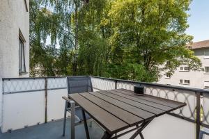 a wooden table and a chair on a balcony at Cooldis 5 !Gratis Parken, Free Parking! in Kreuzlingen