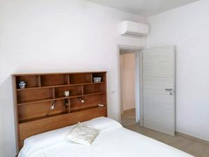 卡布拉斯的住宿－Meli Appartamenti，卧室配有白色的床和木制床头板