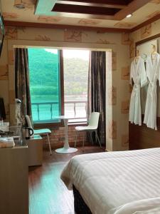 a hotel room with a bed and a large window at Cozy Motel in Yangpyeong