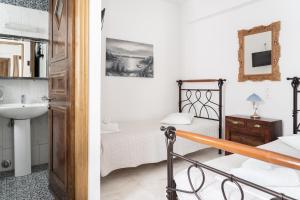 a bathroom and a bedroom with a bed and a sink at Alexandros by the Beach - Serifos in Livadakia +37 photos