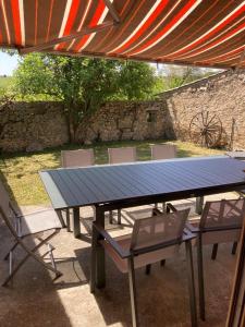 una mesa de picnic y sillas bajo una sombrilla en Secheras: House / Villa - Sècheras, en Sécheras