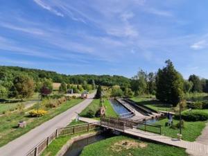 un pont sur une rivière à côté d'une route dans l'établissement Appartement Lacroix-sur-Meuse, 2 pièces, 2 personnes - FR-1-585-91, à Lacroix-sur-Meuse