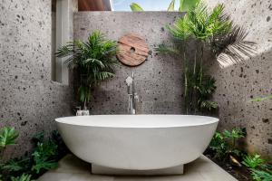 a bath tub in a bathroom with plants at Villa Paso by BaliSuperHost in Ubud