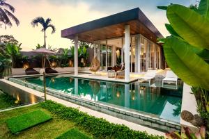 a house with a swimming pool in front of it at Villa Paso by BaliSuperHost in Ubud