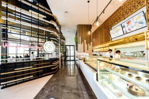 a bakery with a long counter with people in it at Lovina 31-ABAC at One Residence in Batam Center
