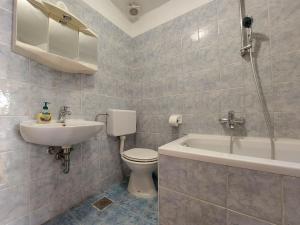 a bathroom with a sink and a toilet and a bath tub at Apartments Baburic in Pinezici