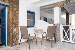 a patio with chairs and a table in a building at Alexandros by the Beach - Serifos in Livadakia