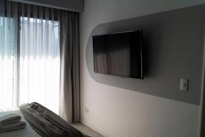 a bedroom with a flat screen tv on the wall at Almagro BA Studio. in Buenos Aires