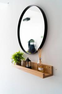 a mirror on top of a wooden shelf with a vase at Almagro BA Studio. in Buenos Aires