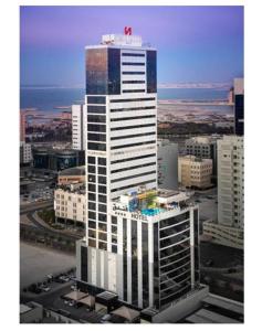 a tall building with a red star on top of it at Swiss-Belhotel Seef Bahrain in Manama