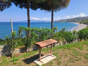 un banc en bois assis sur le côté d'une plage dans l'établissement Beach Studio Kotrona, à Achladi