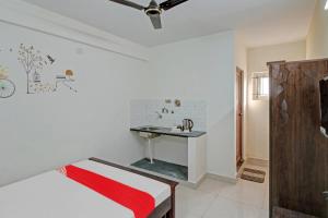 een badkamer met een wastafel en een bed in een kamer bij Flagship Gokul Residency in Bangalore