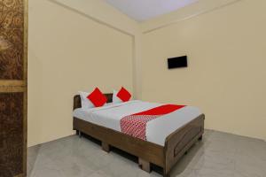 een slaapkamer met een bed met rode kussens erop bij Flagship Hotel Loknath Inn in Chinhat