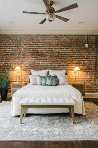 een slaapkamer met een groot bed en een bakstenen muur bij Urban Oasis w/Sunroom-Downtown Columbia in Columbia