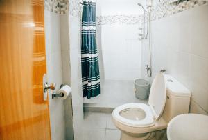 a small bathroom with a toilet and a shower at RedDoorz S&L Apartelle Daraga Albay in Legazpi