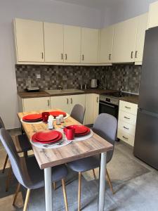 a kitchen with a wooden table with red dishes on it at Modern & Cozy Studio in Koroni