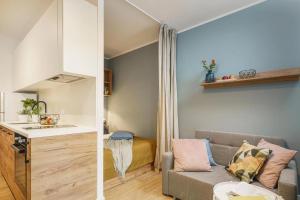 a living room with a couch and a kitchen at Apartamenty na Jaworskiej Wrocław in Wrocław