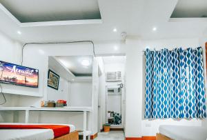 Zimmer mit einem Bett und einem TV. in der Unterkunft RedDoorz S&L Apartelle Daraga Albay in Legazpi