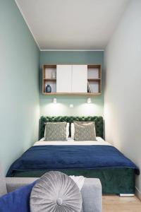 a bedroom with a large bed with a blue blanket at Apartamenty na Jaworskiej Wrocław in Wrocław