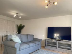 ein Wohnzimmer mit einem Sofa und einem Flachbild-TV in der Unterkunft Luxury Rooms In Furnished Guests-Only House Free WiFi West Thurrock in Grays Thurrock