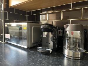 - un comptoir de cuisine avec une cafetière et un four micro-ondes dans l'établissement Luxury Rooms In Furnished Guests-Only House Free WiFi West Thurrock, à Grays