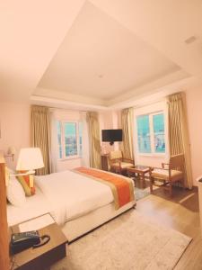 - une chambre avec un lit, un bureau et des fenêtres dans l'établissement Hotel Krishna Kathmandu, à Katmandou