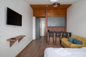 1 dormitorio con sofá, mesa y cocina en Gudauri Ski Resort - Alpic Mountain View Apartments, en Gudauri