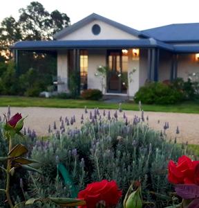 a house with a flower garden in front of it at Red Door Collective - RDC Vineyard Estate in Pokolbin
