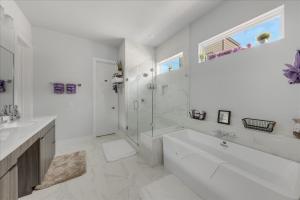 a white bathroom with a tub and a sink at Azaliah Luxe Connection in Houston
