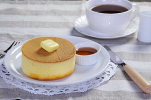 un morceau de gâteau sur une assiette à côté d'une tasse de café dans l'établissement ホテル　RITZ, à Kawagoe