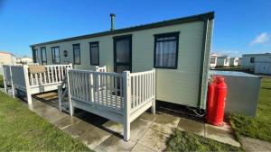 a green tiny house with a red fire hydrant at The Grange - Ingoldmells - Fantasy Island in Ingoldmells