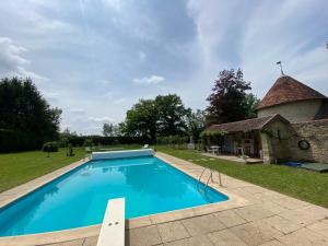a swimming pool in front of a stone building at Le Colombier de Malpas in Quingey
