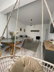 a swing in a living room with a table and a couch at Dio's Apartment 29F-1 in Sfîntu Ilie