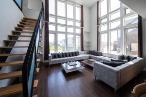 a living room with a couch and a staircase at The BEEHIVE KAMIFURANO in Kami-furano