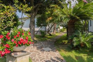 a garden with flowers and palm trees and a walkway at 070 - Villa OLANDA con veranda VISTA MARE a 5 minuti SPIAGGIA con PISCINA CONDOMINIALE in Sestri Levante +46 photos