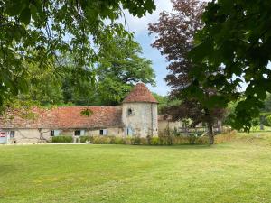 an old stone building with a grass yard at Le Colombier de Malpas in Quingey