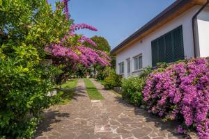 a garden with purple flowers next to a building at 070 - Villa OLANDA con veranda VISTA MARE a 5 minuti SPIAGGIA con PISCINA CONDOMINIALE in Sestri Levante