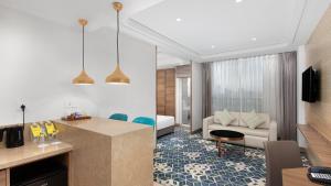 グルガオンにあるHoliday Inn Gurugram Sector 90 by IHGのリビングルーム(キッチン付)、リビングルーム(ソファ付)