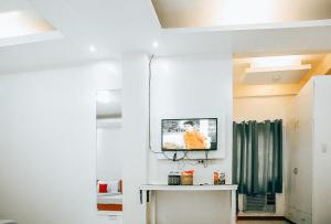 ein Wohnzimmer mit einem TV an der Wand in der Unterkunft RedDoorz S&L Apartelle Daraga Albay in Legazpi